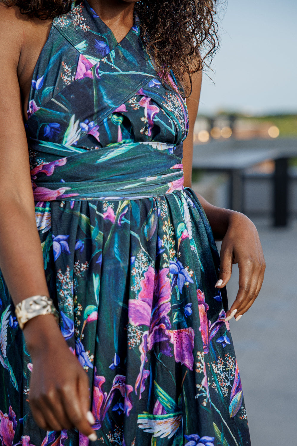 Person wearing a colorful floral dress with a blurred background